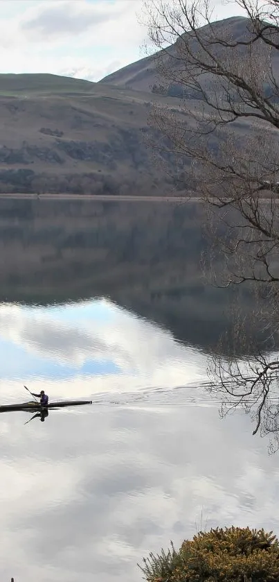 Kayak on a calm lake with mountain reflection.