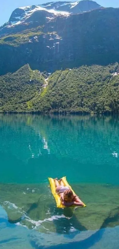 Person on yellow float in tranquil mountain lake.