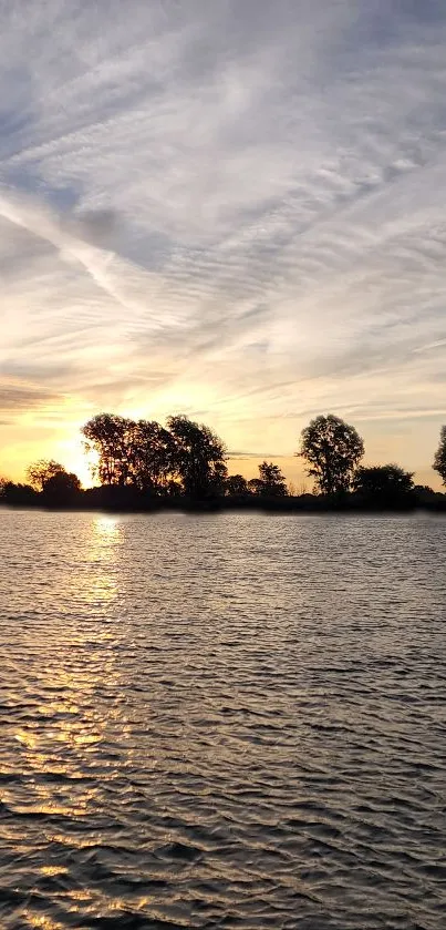 Serene sunset over a tranquil lake with calm waters and a golden sky.