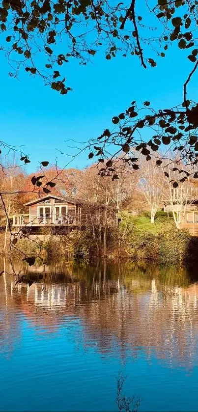 Lakeside view with blue skies and wooden cottages reflecting on calm waters.