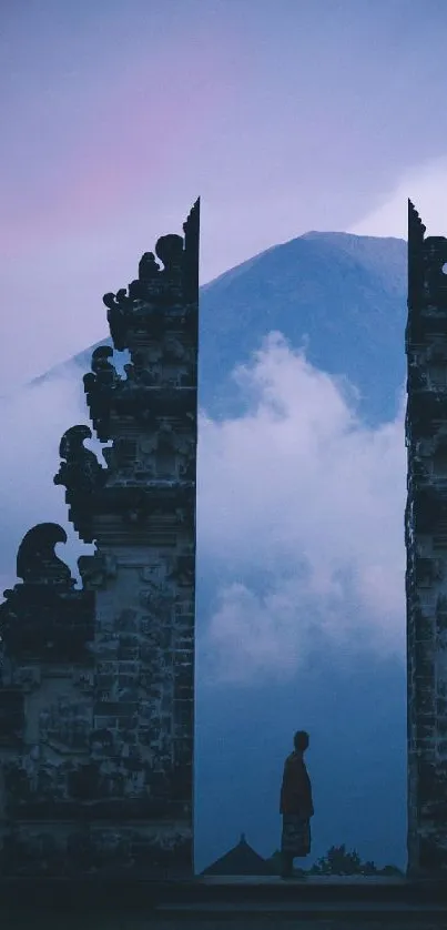 Tranquil mountain scene with traditional gate and misty backdrop.