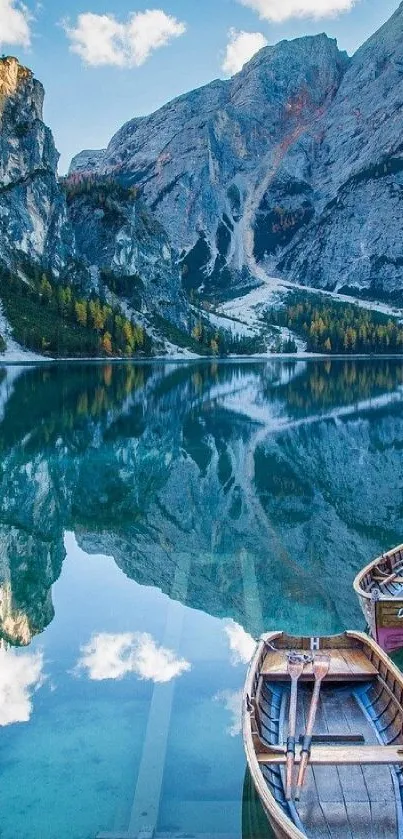 Mountain lake with boats reflecting peaks.