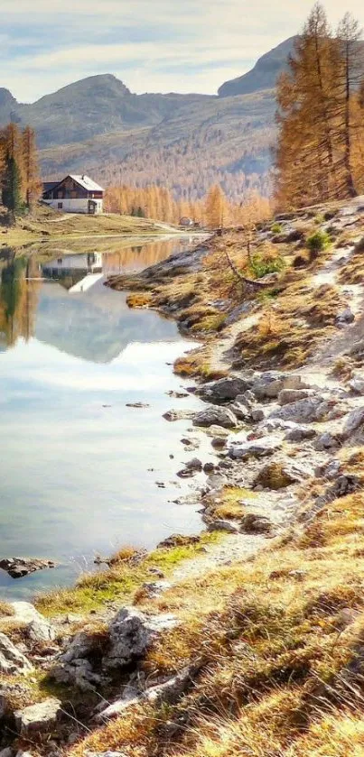 Serene mountain lake with autumn trees and cabin.