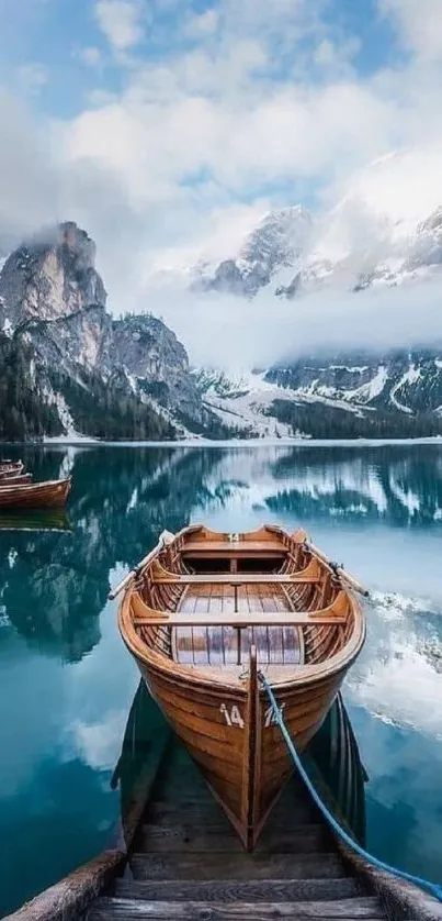 Wooden boat on tranquil lake with mountains in the background.