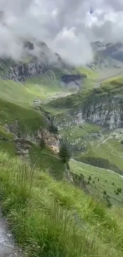 Green mountain landscape with misty clouds.