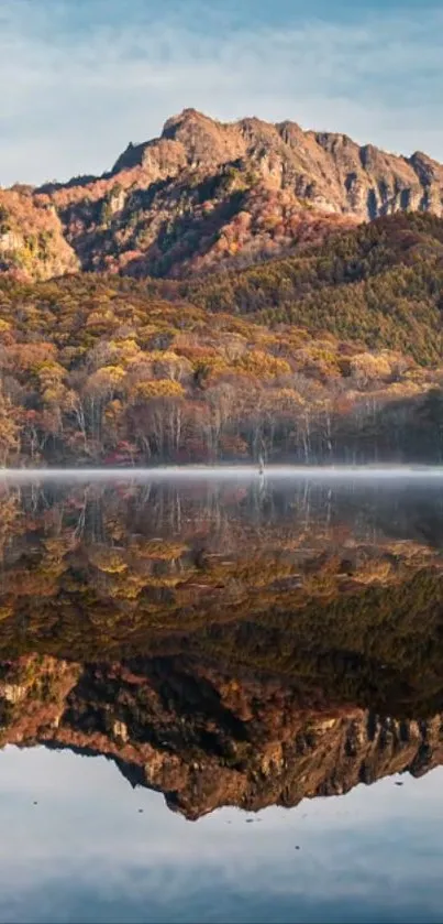 Tranquil mountain landscape reflected in a serene lake with autumn colors.