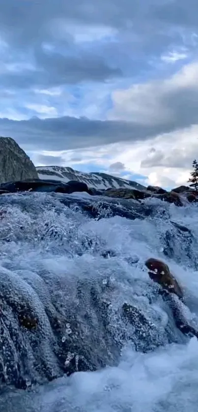 A serene mountain stream flows under a blue sky.