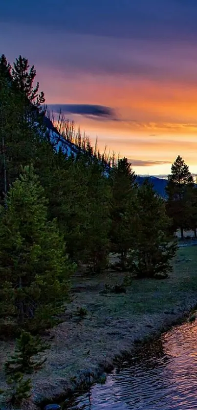 Scenic sunset over mountains and river with vivid orange and blue hues.