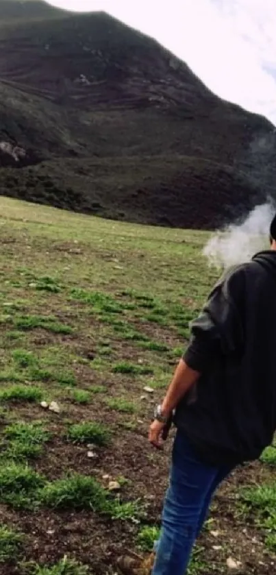 Person overlooking a tranquil green mountain landscape in mist.