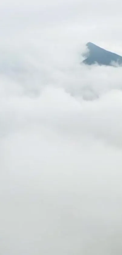 Mist-covered mountain peak with clouds.