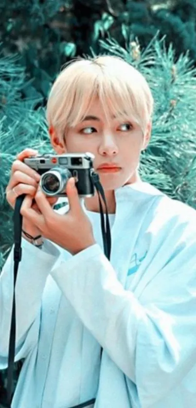 Person holding a vintage camera in nature, surrounded by greenery.