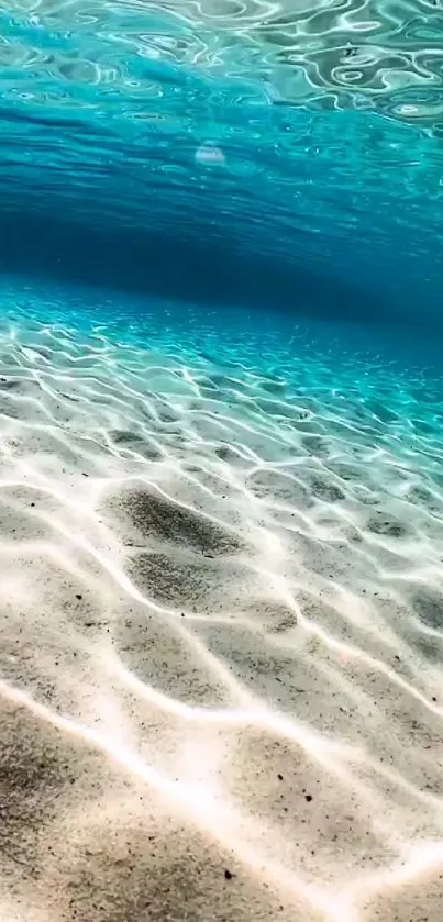 Tranquil ocean floor with sunlight on ripples and blue water hues.