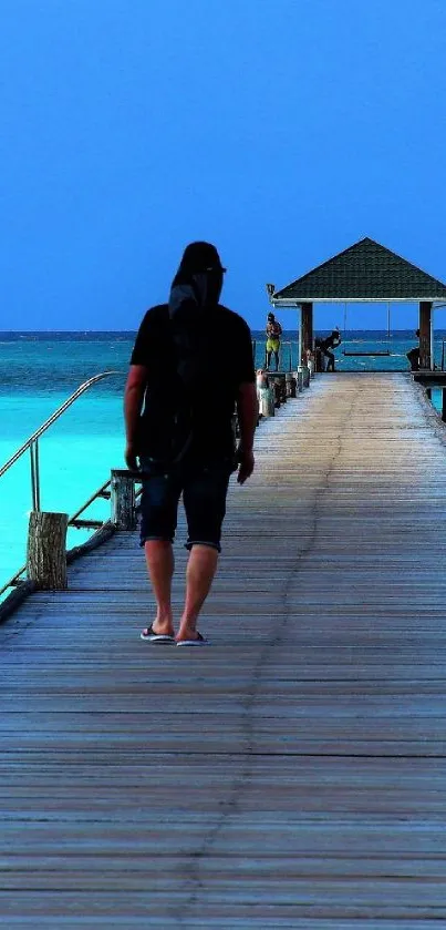 A person walks along a peaceful ocean pier with vibrant blue skies and calm waters.