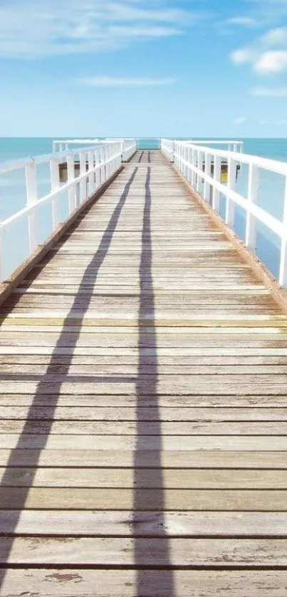 Wooden pier leading into the tranquil ocean under blue skies.