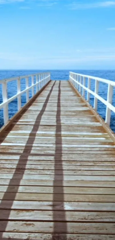 Wooden pier extending into a calm blue ocean with clear skies.