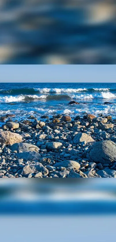 Rocky beach with ocean waves crashing under a blue sky.