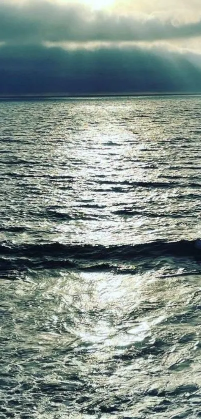 Calm ocean at sunset with a dramatic cloudy sky.