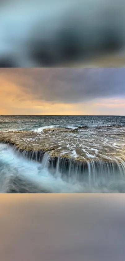 Ocean waves cascade over a rocky surface during a serene sunset.