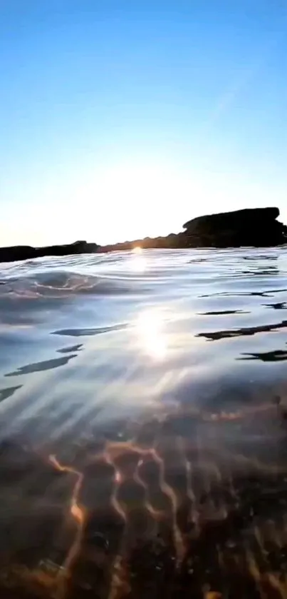 Tranquil ocean sunset with gentle waves reflecting golden sunlight.