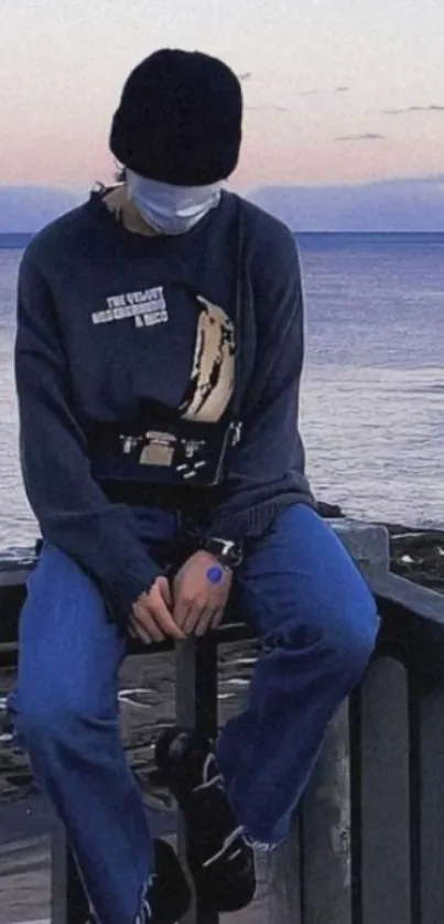 Person sitting quietly with ocean backdrop.