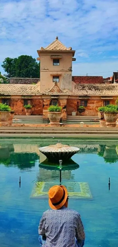 Serene poolside scene with historic building and clear blue sky.