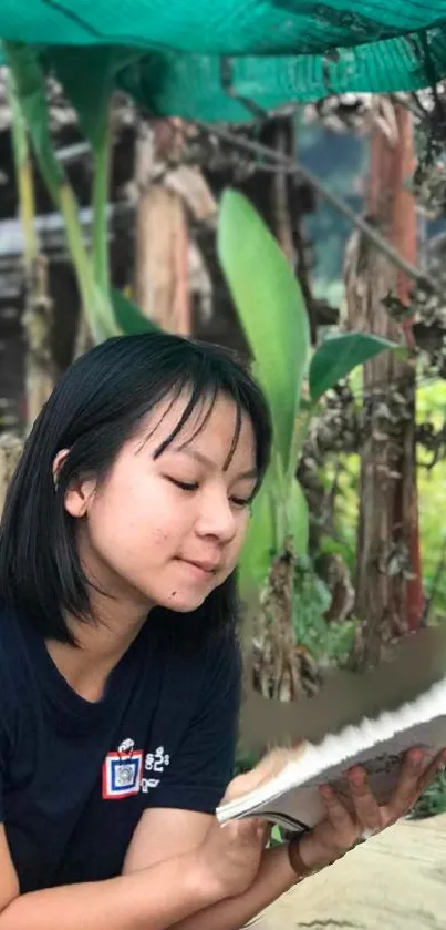 Girl peacefully reading a book outdoors in a lush garden setting.