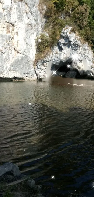 Scenic river cave with sparkling water reflections and lush greenery.