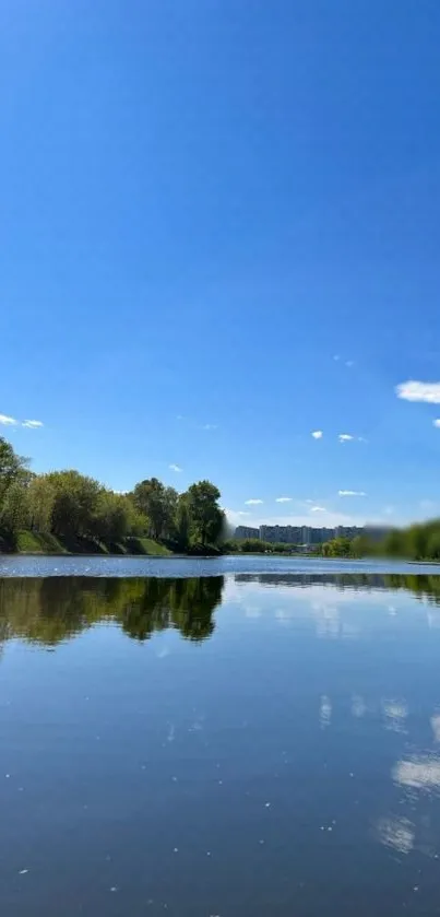 Blue sky and river with lush tree reflections.