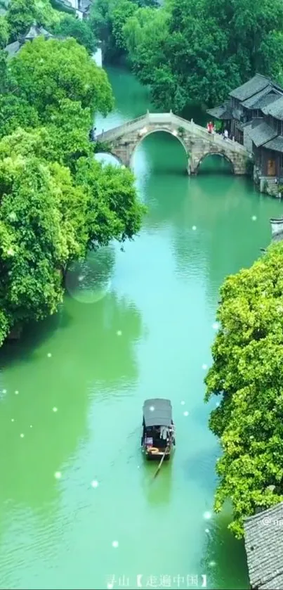 Serene riverside village with bridge and boat amidst lush greenery.