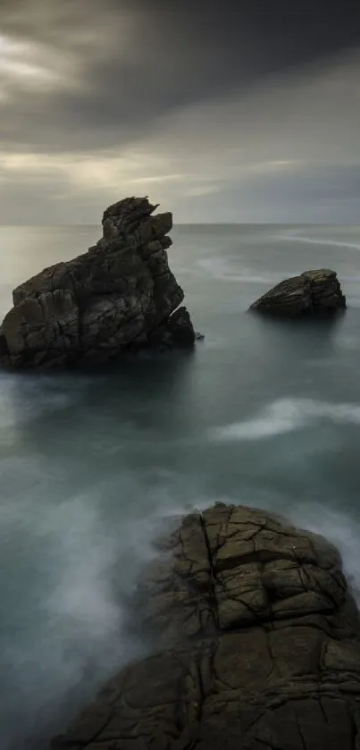 A calm ocean scene with rocky formations under a cloudy sky, perfect for nature lovers.