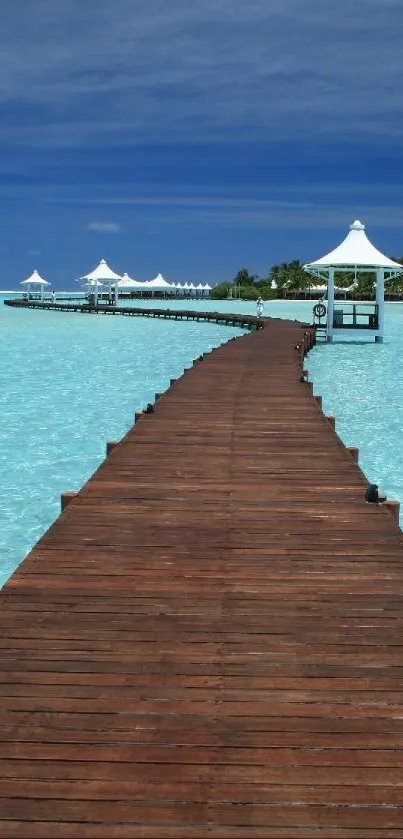 Tranquil boardwalk over turquoise water under a blue sky.