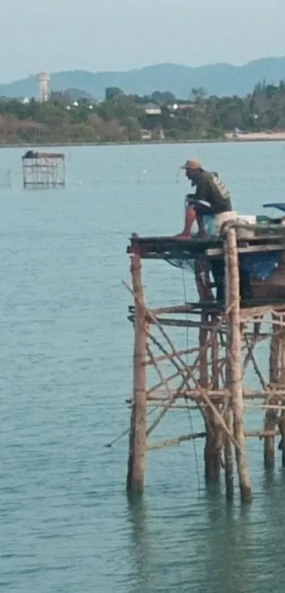 Fisherman on a wooden pier over calm blue waters at the seaside.