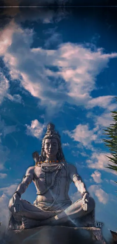 Shiva statue under blue sky with clouds, lush green surroundings.