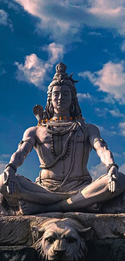 Peaceful Shiva statue beneath a blue sky with clouds.