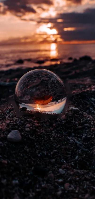 Glass orb on a sunset beach with orange hues and calming atmosphere.