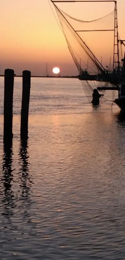 Silhouetted harbor at sunset with fishing boats and orange sky.