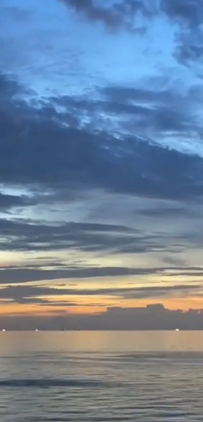 Tranquil sunset over a calm ocean with vibrant evening sky.