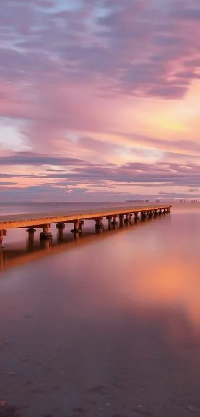 Serene pier at sunset with pink sky reflecting on water.