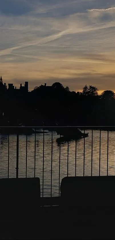 Serene sunset over a tranquil waterfront with silhouetted landscape.