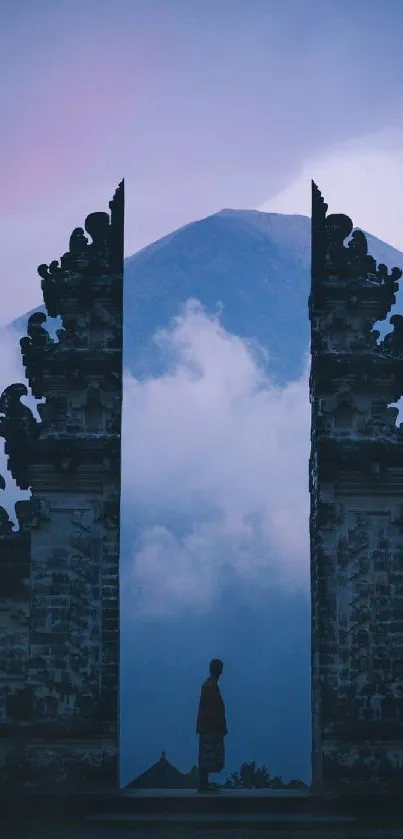 Majestic temple gateway with mountain view surrounded by clouds at dusk.