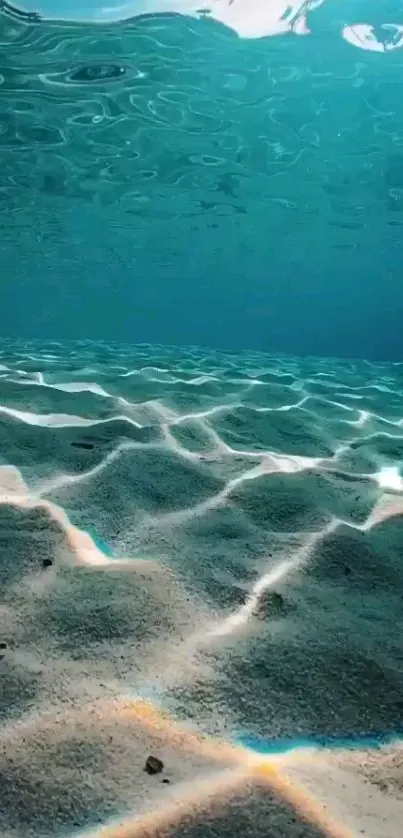 Calming underwater ocean view with sunlit ripples and sandy sea floor.