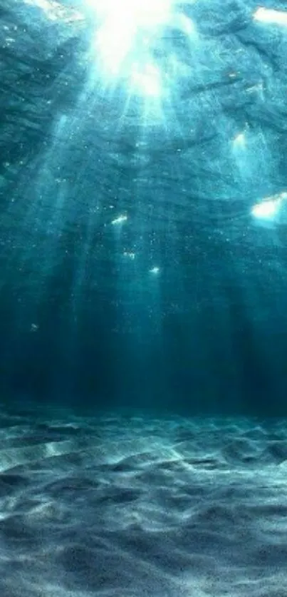 Tranquil underwater scene with sun rays piercing ocean waters.