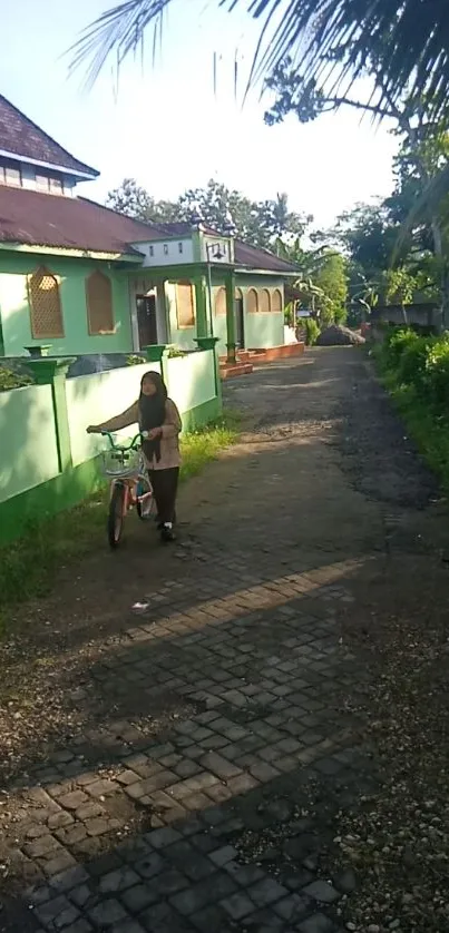 Village pathway with green house and bicycle rider in a tranquil setting.