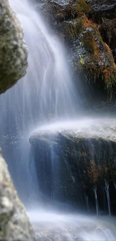 Serene waterfall with cascading water and rocks creating a tranquil scene.