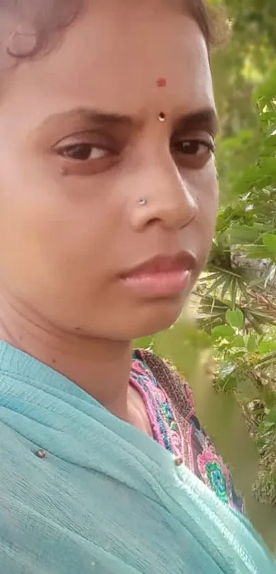 Woman standing amidst green foliage, exuding tranquility.