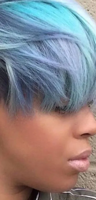 Side profile with vibrant blue hair on a wallpaper.