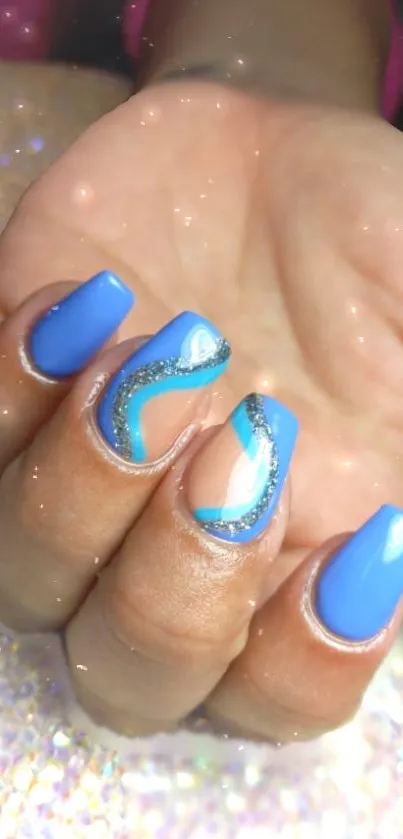 Blue nail art with glitter details showcasing trendy manicure design.