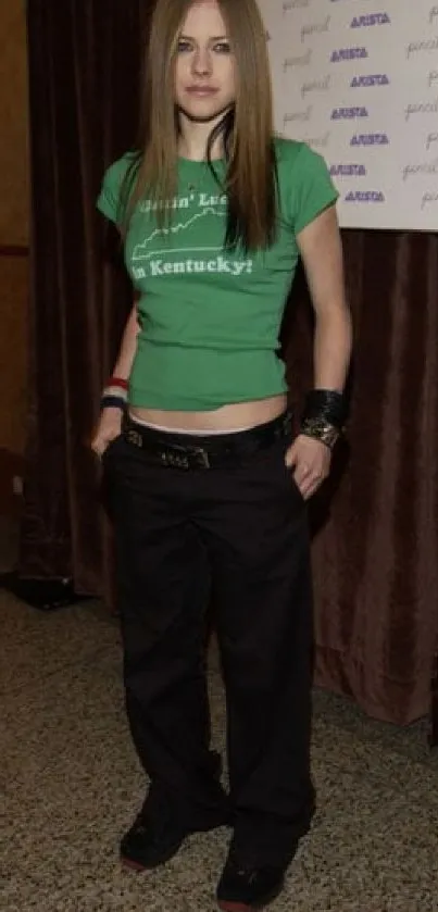 Woman in casual green outfit with dark pants.