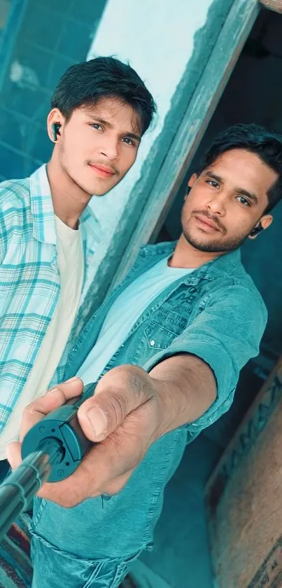 Two friends taking a selfie in vibrant teal tones.