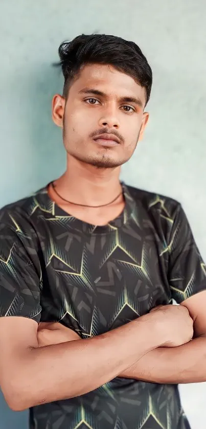 Young man in a geometric-patterned shirt standing confidently.